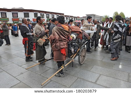 LHASA, TIBET - APRIL 30: Tibetan pilgrims from remote area are greeted in front of the holy Jokhang temple, on April 30, 2013 in Lhasa, Tibet. Many pilgrims travel hundreds of kilometers to arrive in Lhasa.