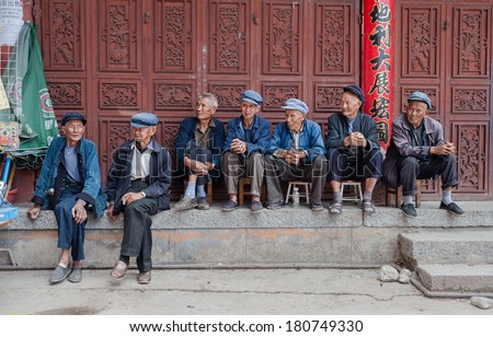 DALI, CHINA - JULY 8: Elderly people sit in front of a social welfare home on July 8, 2013 in Dali, China.In China there is a shortage of elderly care with thousands of applicants on the waiting list.
