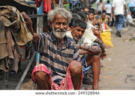 CALCUTTA - APRIL 13: Poor and jobless men waiting on the street for a job on April 13, 2014 in Calcutta, India. India has the largest number of people living below the poverty line of $1.25 per day.
