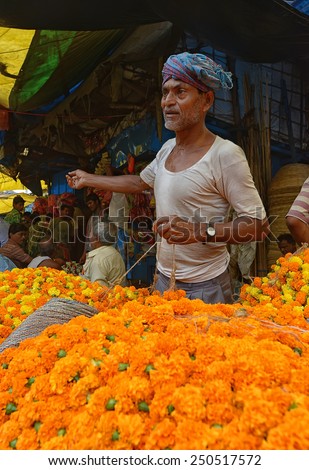 CALCUTTA - APRIL 13: man selling flowers at the Howrah flower market on April 13, 2014 in Calcutta, India. Locals come here to buy flowers for worshiping their gods.