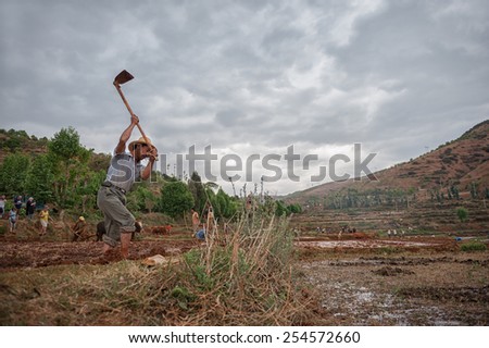 DALI, CHINA - JUNE 7: Chinese farmer works on farmland on June 7, 2014 in Dali, China. Chinese farmers have to work hard and only earn around $800 annual.