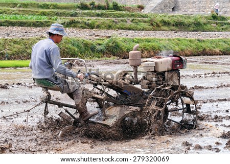 DALI - APRIL 25: Chinese farmer working on rice field on April 25, 2015 in Dali, China. Farmers in China have to work hard and earn average 1800 USD a year.