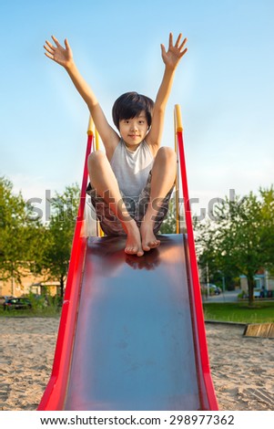 Young Asian boy playing on the slide