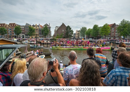 AMSTERDAM - AUGUST 1: people visit the Gay Pride Parade on August 1, 2015 in Amsterdam, The Netherlands. This yearly event is to express the rights of gay people in the world.