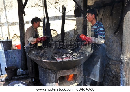 DALI, CHINA - JULY 22: Unidentified men of Chinese Bai ethnic minority making batik (textile dyeing) on July 22, 2011 in Dali, China. These people depend on batik as a way to make a living.