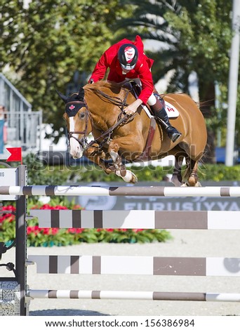 BARCELONA - SEPTEMBER 29: Jonathan Asselin from Canada jumps a horse jumping obstacle at CSIO - Furusiyya FEI Nations Cup Horse Jumping Final Competition, on September 29, 2013, in Barcelona, Spain.