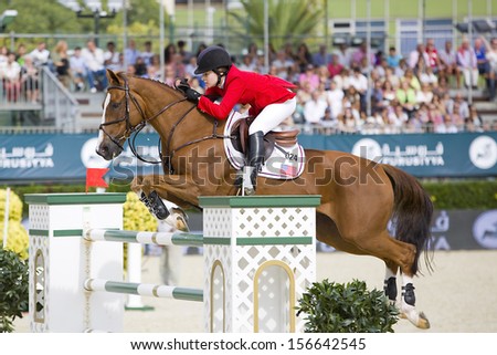 BARCELONA - SEPTEMBER 28: Katherine Dinan from USA jumps a horse jumping obstacle at CSIO - Furusiyya Nations Cup Horse Jumping Consolation Competition, on September 28, 2013, in Barcelona, Spain.