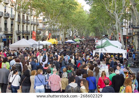 BARCELONA - APRIL 23: People in La Rambla during Diada de Sant Jordi or Saint George\'s Day, on April 23, 2013, in Barcelona, Spain. Traditionally, men gave women roses, and women gave men a book.