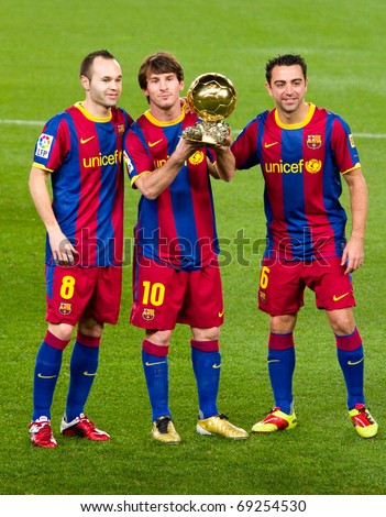 BARCELONA - JANUARY 12: Iniesta, Messi and Xavi offering the Gold Ball Award to the soccer supporters of Football Club Barcelona. January 12, 2011 in Nou Camp stadium, Barcelona (Spain).