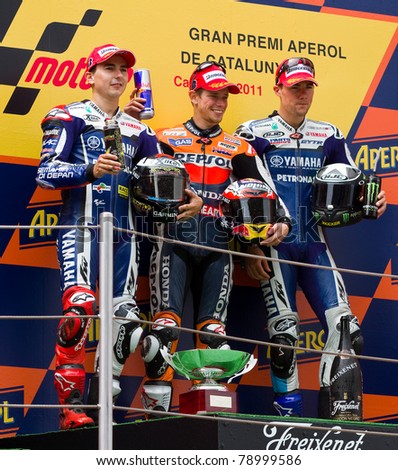 BARCELONA - JUNE 5: Casey Stoner (1st), Jorge Lorenzo (2nd) and Ben Spies (3dr) celebrating their trophies in the podium after the race of MotoGP of Catalunya, on June 5, 2011 in Barcelona, Spain.