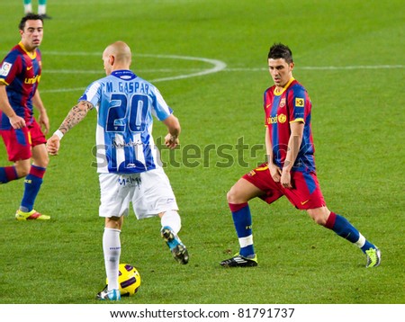 BARCELONA - JANUARY 16: Manolo Gaspar (20) and David Villa (R) in action during Spanish League match between FC Barcelona and Malaga, 4 - 1. January 16, 2011 in Camp Nou stadium, Barcelona, Spain.