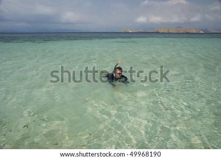 Man with the snorkeling mask in turquoise water, Kanawa Island, Indonesia