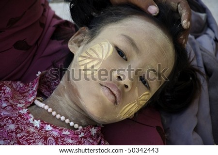 INLE LAKE, MYANMAR - FEB 12: face of the young girl with traditional thanaka on it,  on february 12, 2009 in Inle Lake, Myanmar.