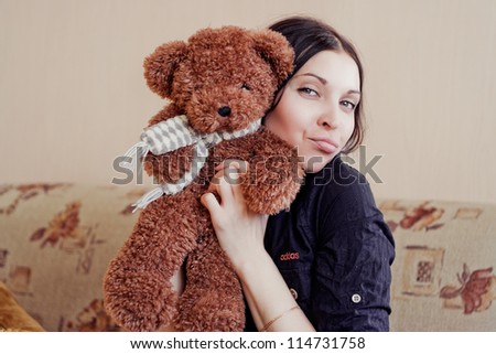Woman sitting on couch with her small teddy bear