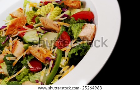Healthy food choice of mixed salad and grilled chicken pieces all on white plate