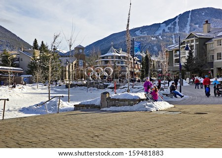 WHISTLER VILLAGE, BRITISH COLUMBIA - FEB 10: Tourists roaming Olympic Village, Whistler, British Columbia, on February 10, 2013 with views of Whistler and Blackcomb Mountain behind the village.