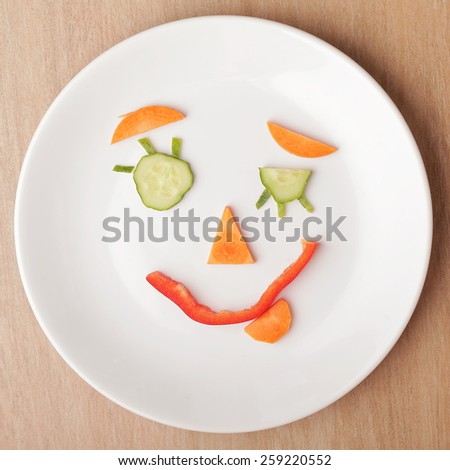 Smiley face made of vegetables on a plate