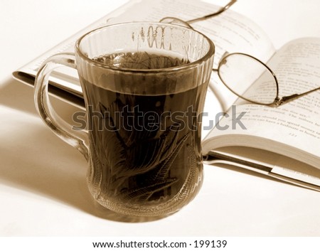 Cup of black coffee, book and glasses; sepia