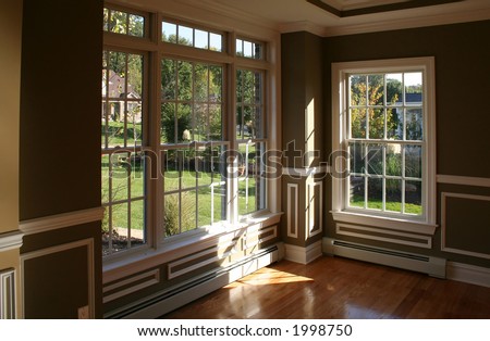 Sunny corner in living room with garden view through beautiful windows