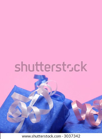 Gifts wrapped in blue with pink, white and blue ribbon on pink background