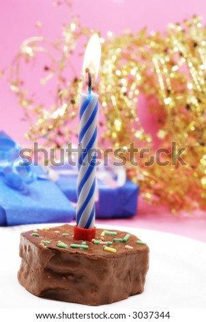 Birthday candle and blue gifts on pink with gold star decorations