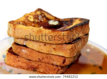 Stack of cinnamon french toast with butter and syrup with white background.