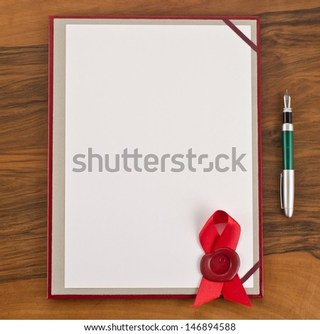 Blank paper with red wax seal and pen on wooden background