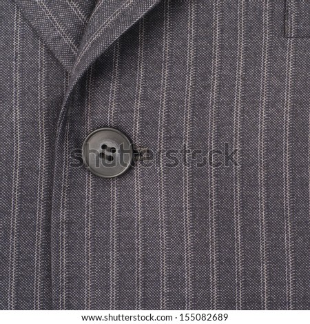 Close up of a button on a striped business suit coat