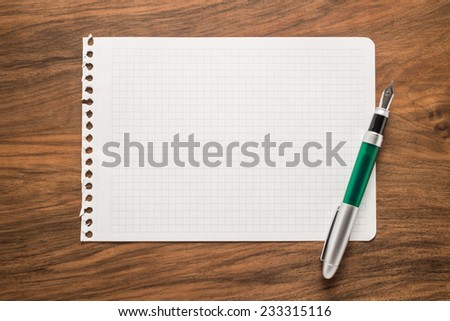 Paper with pen on a wooden desk