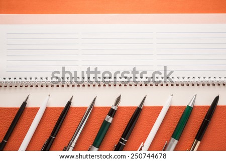 Set of different pens on a notepad