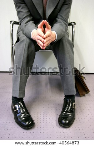 Person sitting impatiently, waiting for a job interview