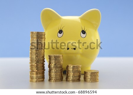 Yellow Piggy bank with stacks of coins