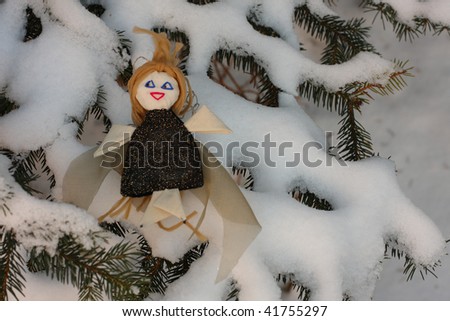 victorian handmade toy angel on fir tree with snow horisontal