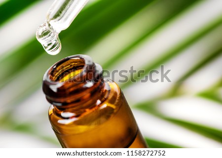 herbal essence. alternative medicine. essential oil dropping from pipette to the bottle