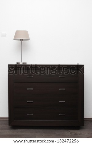 brown commode with lamp in bright minimalism interior