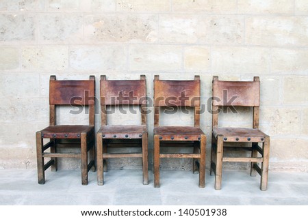four vintage chairs at the stone wall