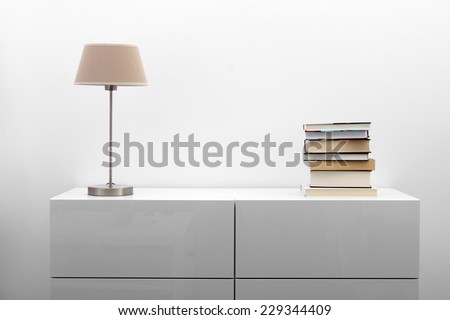 white commode with lamp and books in bright minimalism interior