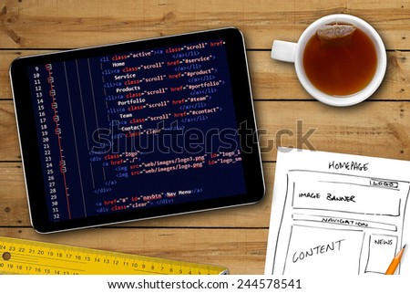 website wireframe sketch and programming code on digital tablet screen