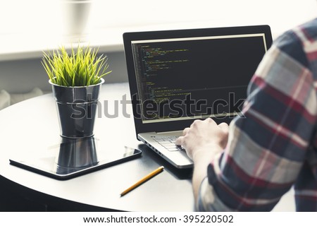 programmer working on laptop at office. focus on programming code