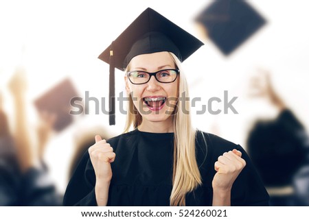 college graduation - happy woman wearing gown and cap celebrating