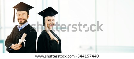 graduation - happy students wearing gown and cap. copy space