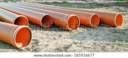Orange plastic pipes for drainage or the sewerage on a construction site