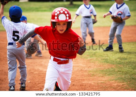 Youth little league baseball boy running bases Youth little league baseball boy running bases