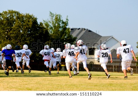 Teen football team running during practice