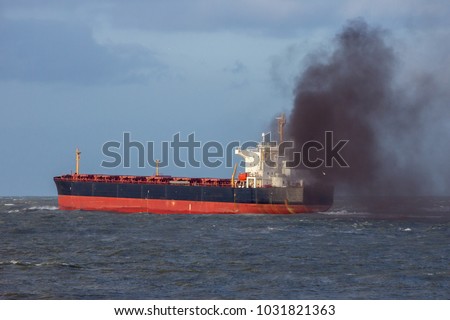 Industrial cargo ship causing air pollution leaving the Port of Rotterdam.