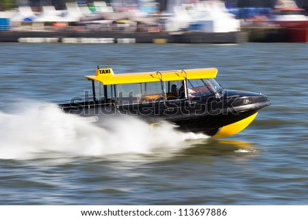 Water taxi speeding over the Meiuse river in Rotterdam, The Netherlands