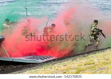 DEN HELDER, THE NETHERLANDS - JULY 7: Dutch Marines running through smoke during an amphibious assault demo during the Dutch Navy Days on July 7, 2012 in Den Helder, The Netherlands