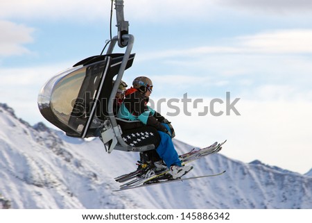 FLACHAU, AUSTRIA - DEC 27: Skiiers on a ski lift to a piste in Flachau, Austria on Dec 27, 2012. These pistes are part of the Ski Armada network, the largest of Europe