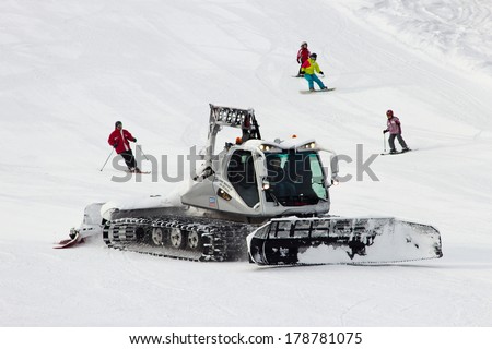 FLACHAU, AUSTRIA - JAN 7: Snow groomer on the ski piste in the ski resort town of Flachau, Austria on Jan 7, 2012. These pistes are part of the Ski Armad network, the largest of Europe.