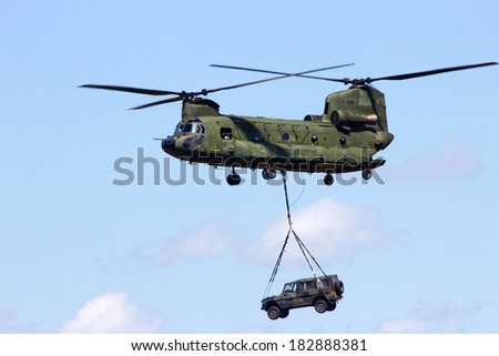 VOLKEL, NETHERLANDS - JUNE 15: Dutch Air Force CH-47 Chinook transports a vehicle during the Air Power Demo at Royal Netherlands Air Force Days June 15, 2013 in Volkel, Netherlands.
